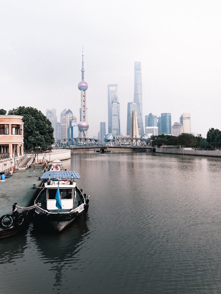 A motorboat docked by the Huangpu River with Shanghai's iconic skyline in the background.