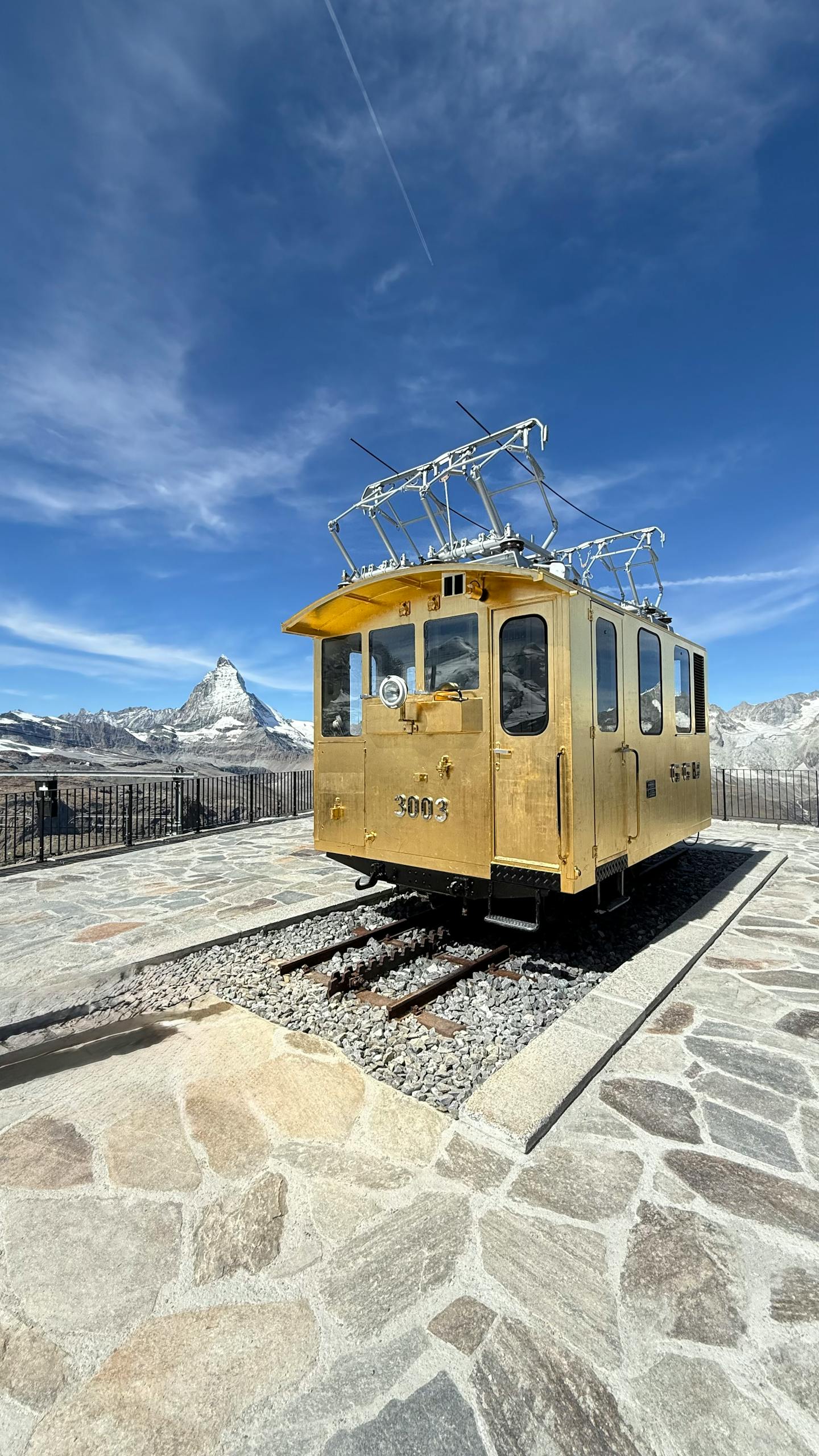Vintage yellow train car at Gornergrat with the Matterhorn in view.